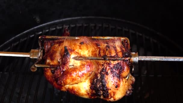 Poulet parfumé est rôti sur brochettes sur le gril rotatif — Video