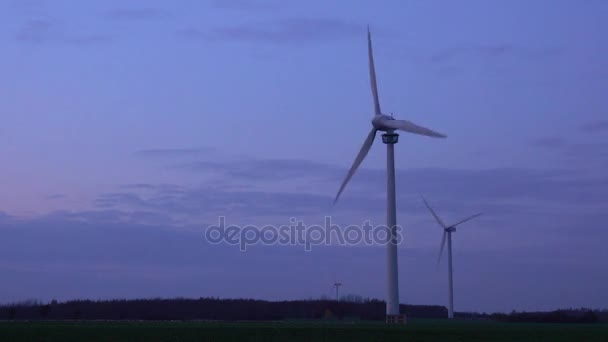 Три современные ветряные турбины, генерирующие устойчивую энергию в поле вечером в пригороде Ганновера в Нижней Саксонии. Германия . — стоковое видео