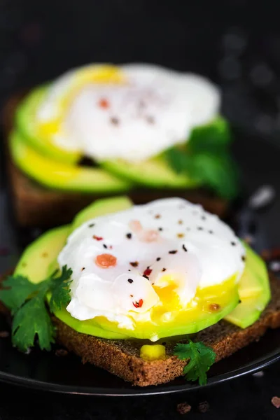Toasts with avocado and poached eggs — Stock Photo, Image