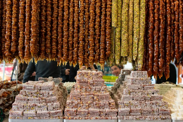 Background of sweet dry fruits in vertical bars with piles of turkish delicacies below