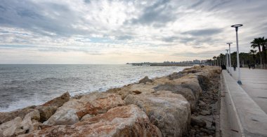 Kayalar bulutlu bir günde deniz kenarını denizden ayırır.