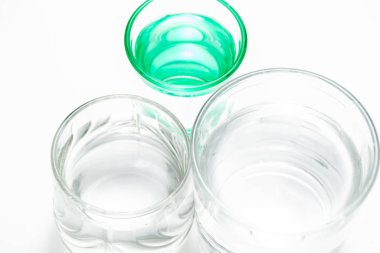 Şeffaf bardaklar ve suyla birlikte yeşil bir bardak.