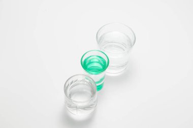 Şeffaf bardaklar ve suyla birlikte yeşil bir bardak.