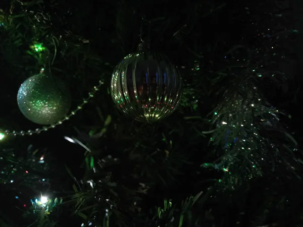 Christmas tree ornaments with globes, installation and tinsel