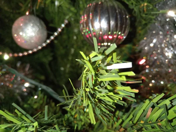 Christmas tree ornaments with globes, installation and tinsel