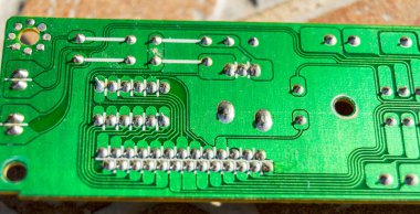 Kahverengi karo arka planında lehimlenen elektronik bileşenler için tasarlanmış yeşil lehim istasyonu