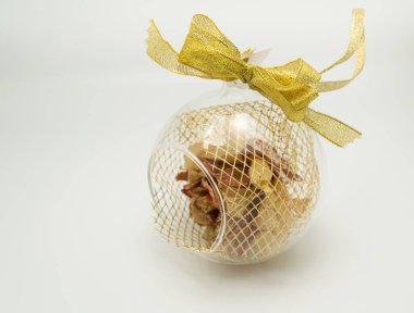 İçinde yapay çiçek olan cam küre süsü ve altın süslemeler.