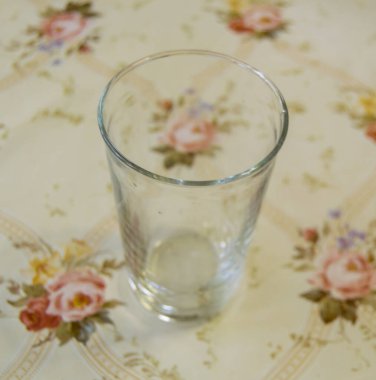 Masanın üzerinde duran boş bardak.