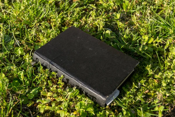 緑の草の上の黒い本 — ストック写真