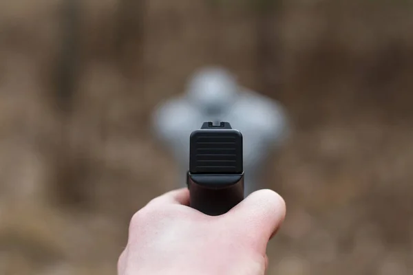 Fotografering från en pistol. Omlastning pistolen. Mannen siktar på målet. Skjutbana. Man skjuter usp pistol på target i inomhus skjutbana — Stockfoto