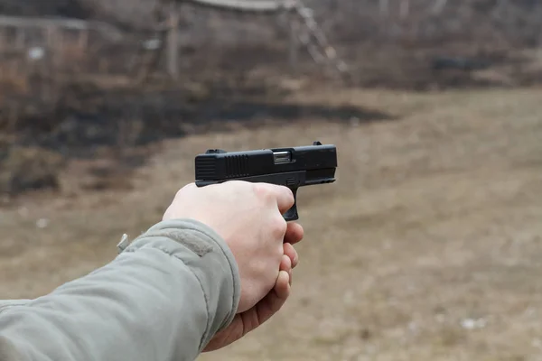 Shooting from a pistol. Reloading the gun. The man is aiming at the target. Shooting range. Man firing usp pistol at target in indoor shooting range — Stock Photo, Image