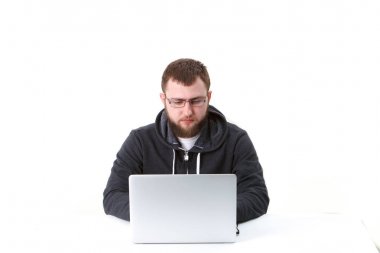 Gözlüklü programcı dizüstü çalışır. İzole, beyaz bir arka plan üzerinde bir kişi. Sakin.