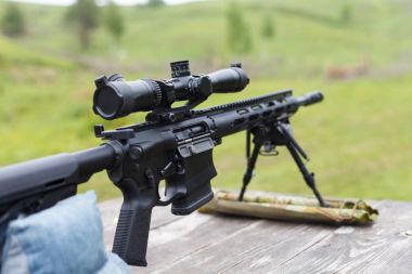 Keskin nişancı tüfeği. Yatay olarak. Ormanın içinde masaya.