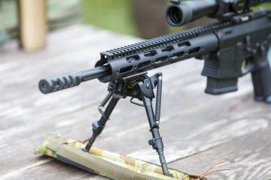 Keskin nişancı tüfeği. Yatay olarak. Ormanın içinde masaya.