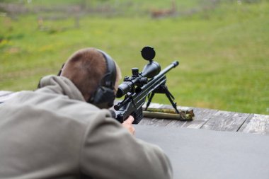 Hedefe ateş etmek bir adam keskin nişancı hazırlar.