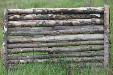 Yeşil çim sahada ahşap bir bariyer duruyor.