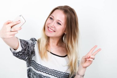 Kız ofis çalışanı selfie iş yapıyor. Beyaz bir arka plan üzerinde.