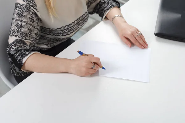 Woman signs documents on white background.