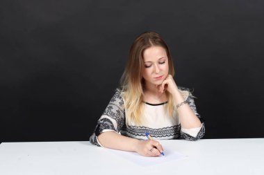 Kadın siyah arka plan üzerine belgeleri imzalar.