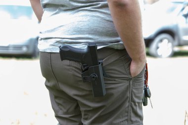 Tabanca kılıfın içinde. Tetikçi trenler. Hedefe ateş etmeye hazırlanıyor