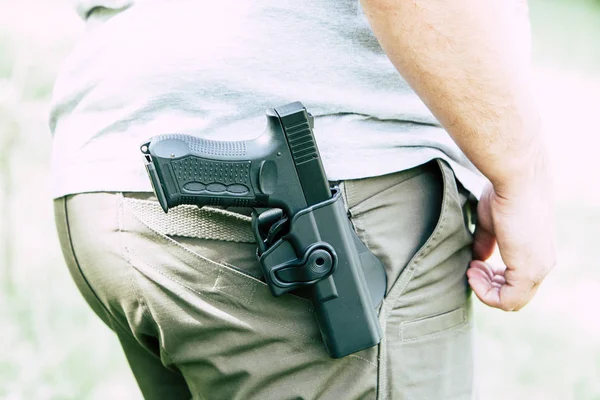 Pistola en la funda. El tirador entrena. Se prepara para disparar al blanco — Foto de Stock