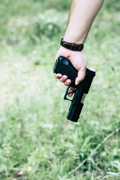 The gun is in his hand. The man is ready to shoot at the target. — Stock Photo, Image