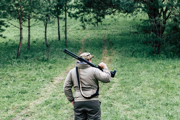 Hunter com uma arma. Em pé na floresta e à espera de presas — Fotografia de Stock