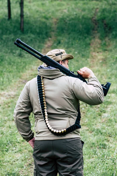 Jägare med en pistol. Stående i skogen och väntar på byten — Stockfoto