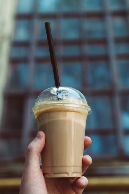 Plastik bir kap içinde lezzetli içecek. Soğuk kahve.