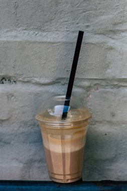 Plastik bir kap içinde lezzetli içecek. Soğuk kahve.