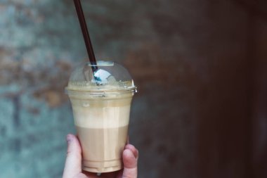 Plastik bir kap içinde lezzetli içecek. Soğuk kahve.