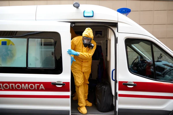 02.28.2020 Oekraïne. Kiev. Onderricht. Artsen vervoeren de patiënt voor het coronavirus naar een ziekenhuis voor infectieziekten. Artsen in beschermende pakken. Patiënt met een beschermend masker. — Stockfoto