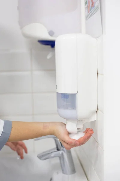 Il dottore disinfetta le mani. Il medico si lava le mani con sapone e tratta con un antisettico . — Foto Stock