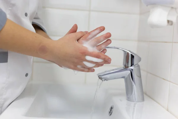 The doctor disinfects the hands. The doctor washes his hands with soap and treats with an antiseptic. — Stock Photo, Image