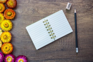 Kalem ile ahşap masa üstünde açılan boş sayfa defter kalemtıraş