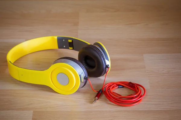 Casque jaune avec 3,5 mm. prise stéréo sur fond bois — Photo