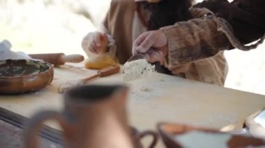 Canale Monterano, İtalya - Mayıs 2018: İtalya şehir Monterano 'da ortaçağ yaşam tarzı ve etkinliklerinin yeniden inşası, orta yaşlı yerel fırıncı ahşap tahtaya yüksek kaliteli un döker ve hazırlanır.