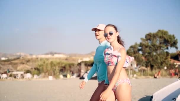 Mam en jonge dochter wandelen langs het strand en genieten van tijd samen door te brengen. Zomervakantie, fijne vakantie en reisconcept. Langzame beweging — Stockvideo