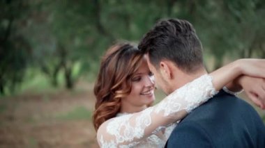Mutlu evli çiftin samimi gerçek duyguları, yeni evliler kucaklaşıp birbirlerine bakıyorlar, mutlu, gülen bir çift güzel yeşil bahçede eğleniyor. Tutku ve aşk Islak Cadılar Bayramı erkeği