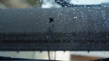 Çamaşır tünelinden geçen bir arabanın görüntüsü. Arabanın içinden araba yıkama, araba yıkamadan sonra ıslak ön cam.