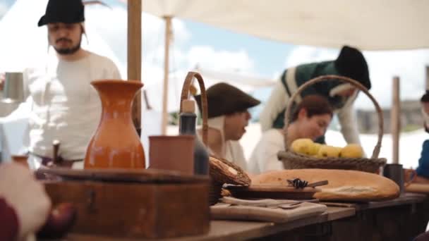 Canale Monterano, İtalya - Mayıs 2018: Eski köy toplumunda yemek yiyen, konuşan ve dinlenen geleneksel ortaçağ giysi grubu. Köydeki ortaçağ köylülerinin hayatı — Stok video
