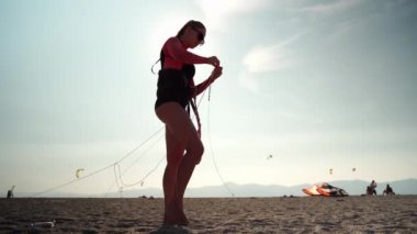 Güneşli Calabria 'da deniz sahilinde aşırı su sporu hazırlığı. Dalgıç kıyafetli kadın sörfçü, yelek ve suya girmeden önce koruyucu gözlük.