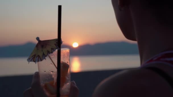 Flicka dricka färsk mojito med dricka halm, titta i fjärran och njuta av fantastisk marin solnedgång. Silhuett av ung tonåring vid havet stranden avkopplande och dricka dryck. Sommarsemester — Stockvideo