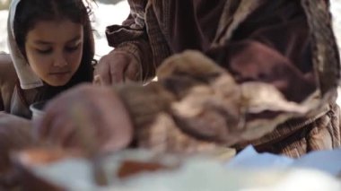 Kanada Monterano, İtalya - Mayıs 2018: Ortaçağ köylüsü ve geleneksel orta çağ kıyafetleri içinde taş fırında pişirmek için hamur hazırlayan torunu. Baker hamuru fırına koyuyor