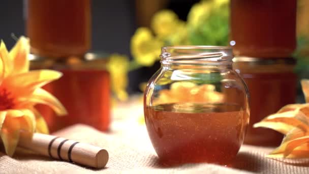 Miel dorada de alta calidad en tarros. Producto natural puro lleno de vitaminas, frascos preparados para la venta en el mercado rústico. Miel floral dulce gruesa — Vídeos de Stock