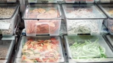 Plastik kaplarda çeşitli sağlıklı kurutulmuş meyvelerle inanılmaz renkli bir tezgah. Vitamin ve minerallerle dolu kurumuş meyve, insan vücudu için sağlıklı besin. Esnaf pazarı kavramı