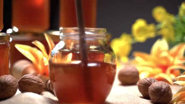 Mel dourado de cristal puro em jarra, mexendo néctar doce com pau de madeira. Produto de abelha natural cheio de vitaminas. Frascos de mel preparados para o mercado de artesanato. Conceito de apicultura — Vídeo de Stock