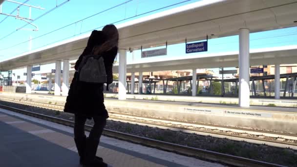 Menina bonita de pé sozinho na plataforma da estação de trem e segurando dois bilhetes de viagem. Mulher turista esperançosa à espera de passar de comboio. Menina perdeu sua última chance de pegar o trem, tarde para — Vídeo de Stock