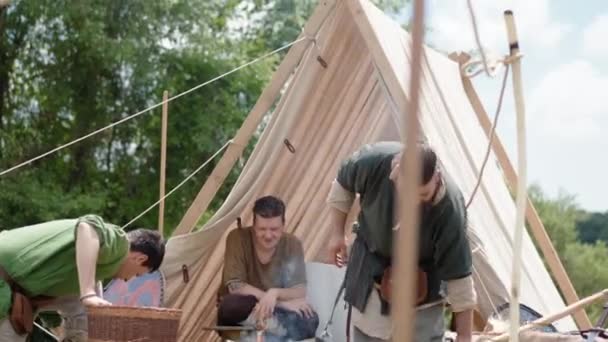 CANALE MONTERANO, WŁOCHY - MAJ 2018: Odtwarzanie średniowiecznego stylu życia w Monterano, chłopi rozłożyli namiot i przygotowywali drewno do rozpalania ognia na ziemi do gotowania i rozgrzewania w nocy — Wideo stockowe