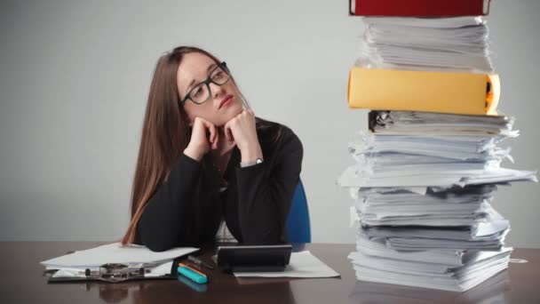 Gestresste financieel adviseur zit aan tafel en kijkt naar stapel onvoltooide documenten — Stockvideo